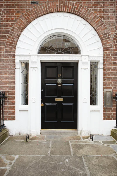 Una puerta negra en Dublín, Irlanda. Arched georgiano puerta de la casa fron — Foto de Stock