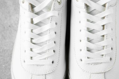 Yuvarlak deriden yapılmış beyaz plimsolls, uyumlu bağcıklar, kumaş 