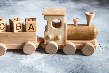 Çocukların tahta oyuncakları. Çocuk arabalı ahşap tren. Doğal ahşap inşaat seti. Eğitim ekipmanları. Çocuk ahşap lokomotifi ve çeşitli yük arabaları..