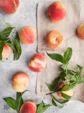 Gri arka planda birkaç olgun şeftali. Tahtadaki şeftali meyveleri. Yeşil yaşam konsepti. Organik yiyecekler.