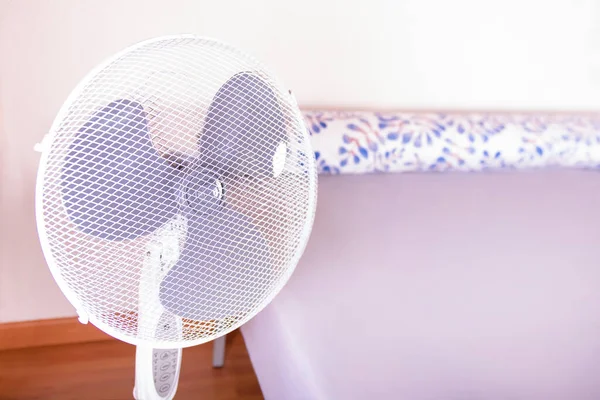 Electric fan that cools the air during a hot day at bedroom.Photo