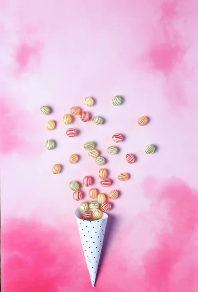 Pembe arkaplanda renkli şekerler