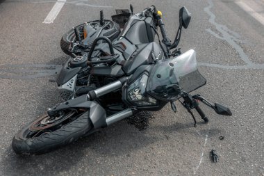 Motosiklet bir geziden sonra kaldırımda yatar. Ciddi bir kaza. Kaza, yakın planda. Kontrolü kaybettim ve düştüm. Araba sürme tehlikesi. Başka bir araca çarpmış..