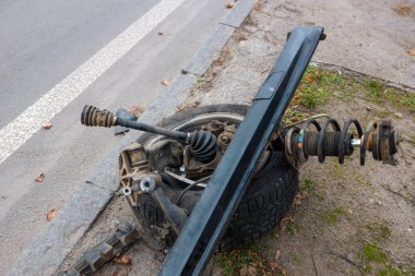 Bir arıza ya da araba kazasından sonra, yolun kenarına bırakılmış bir yığın çarpık ve kırık araba parçası. Görüntü araba kazasını ve trafik kazasının sonrasını gösteriyor.