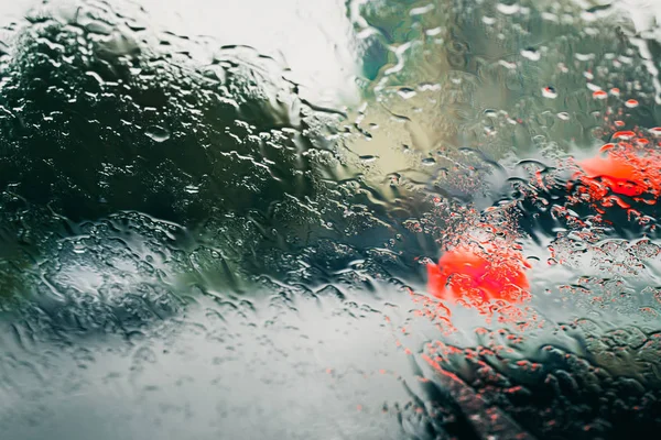 City road sedd genom regnet droppar på bil vindrutan — Stockfoto