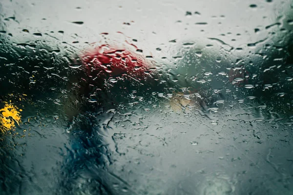 車のフロント ガラスに雨を通して見た都市道路を削除します。 — ストック写真