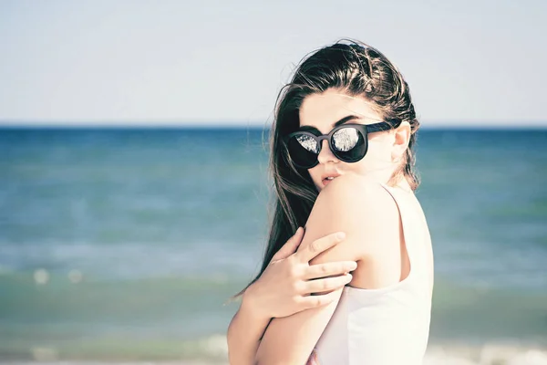 美丽的女孩与长发在时髦的太阳镜享受她的时间在海滩上 — 图库照片