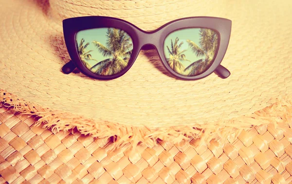 Sombrero de paja con gafas de sol de moda negras con reflejo de palmas —  Fotos de Stock