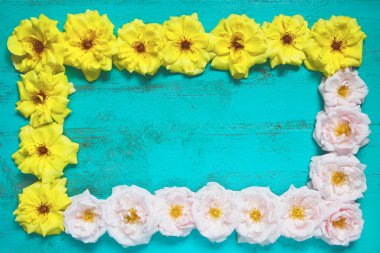 Taze sarı ve pembe bahçe gül ile eski boyalı ahşap masa