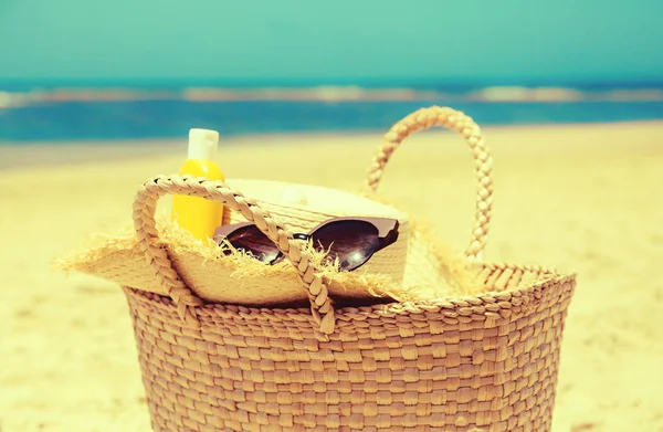 Солом'яний мішок, солом'яний капелюх, пляшка сонцезахисного лосьйону та сонцезахисного скла — стокове фото
