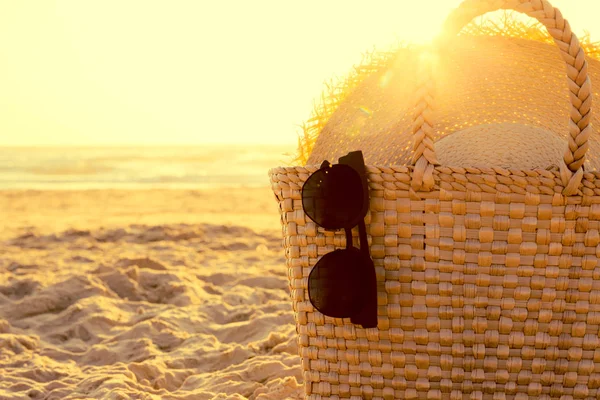 Strohsack, Strohhut und Sonnenbrille mit Meeresstrand bei Sonnenuntergang l — Stockfoto