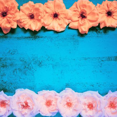 Taze sarı ve pembe bahçe gül ile eski boyalı ahşap masa