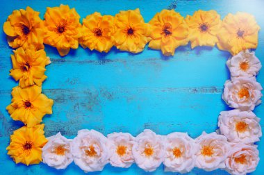 Taze sarı ve pembe bahçe gül ile eski boyalı ahşap masa