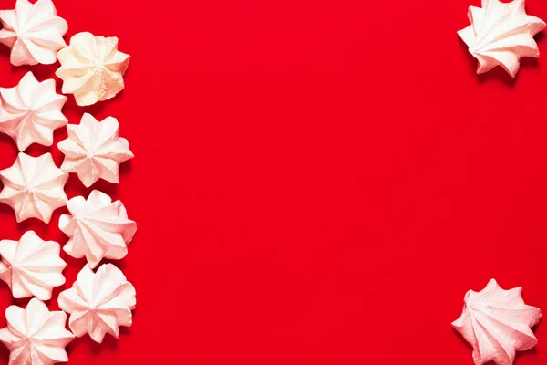 Małe białe bezy na czerwonym tle. Uroczystość i uroczystość — Zdjęcie stockowe