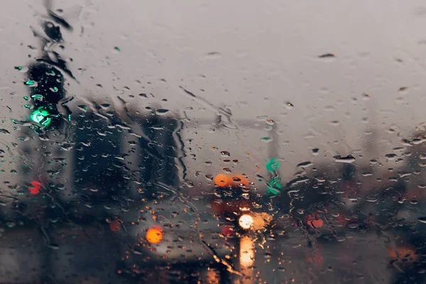 街の道路は雨を介して車のフロントガラスに値下がりしました 水の滴に焦点を当てます — ストック写真