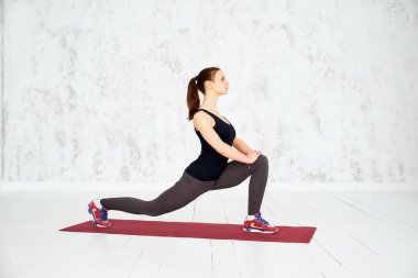 Önce eğitim ısınıyor. Genç güzel genç kadın spor giyim germe yapıyor. Fitness, spor, eğitim ve insan kavramı.