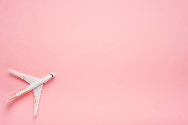Son moda pembe bir arka plan üzerinde üstten görünüm bir uçağın. Yaz parlak renk. Seyahat kavramı.