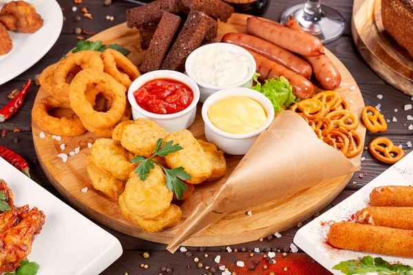 Bira aperatifler kapatın. Izgara sosis, soğan halkaları ve soslar ile nuggets