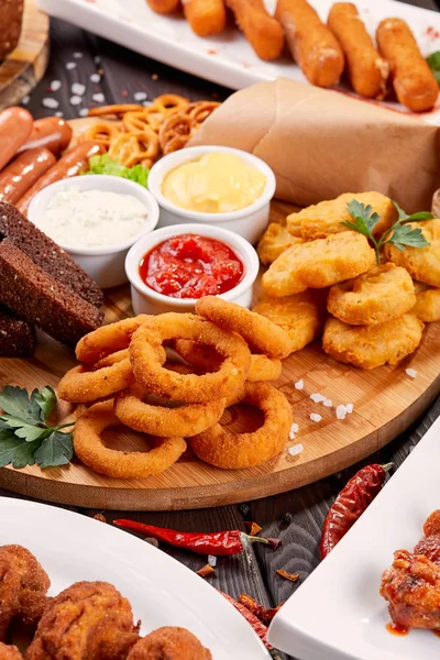 Bira aperatifler kapatın. Izgara sosis, soğan halkaları ve soslar ile nuggets