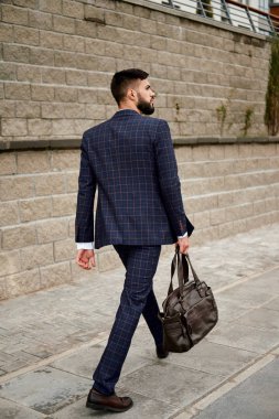 Çekici işadamı seyahat çantası elinde sokakta yürürken