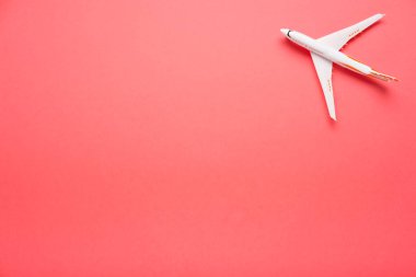 Son moda pembe bir arka plan üzerinde üstten görünüm bir uçağın. Yaz parlak renk. Seyahat kavramı.