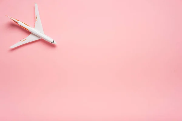Vista superior de un avión sobre fondo rosa de moda. Color brillante del verano. Concepto de viaje . — Foto de Stock