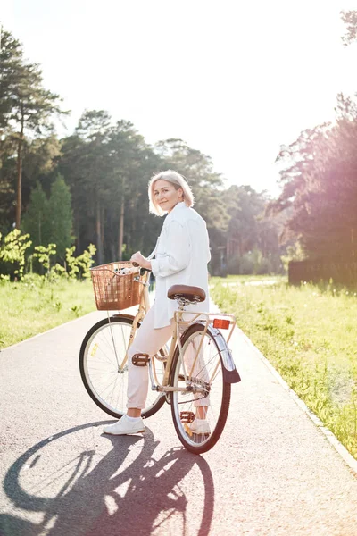 Mulher bonita nova que monta uma bicicleta em um parque. Pessoas activas. Ao ar livre relaxar — Fotografia de Stock