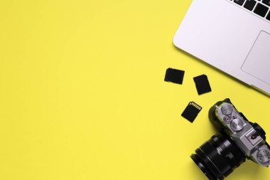 Bir masaüstü bir kamera, bir dizüstü bilgisayar, bir dizüstü bilgisayar ve bir mavi Resepsiyon arka plan - kopya alanı bir hafıza kartına oluşan bir fotoğrafçı üstten görünüm.