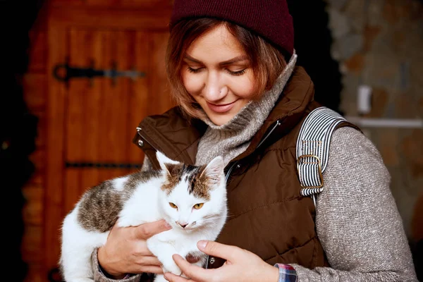 Macska lány önkéntes, a hajléktalan állatok menedéket a kezében. Háziállat — Stock Fotó