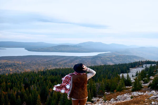 Wanderlust en reizen concept. De vrouw van de reiziger in hoed kijken naar bergen. Wandelen op de berg. Atmosferische moment — Stockfoto