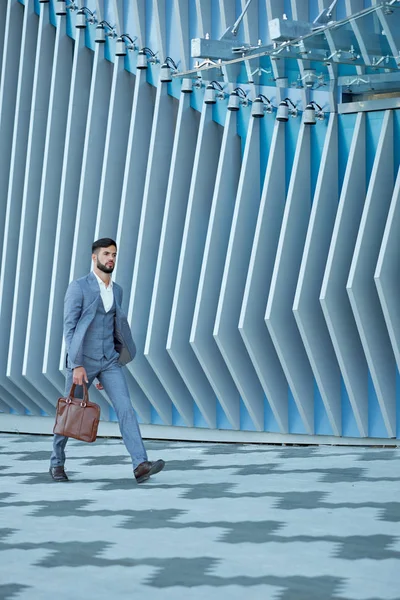 Uomo d'affari in abbigliamento formale con borsa in pelle che cammina in città — Foto Stock