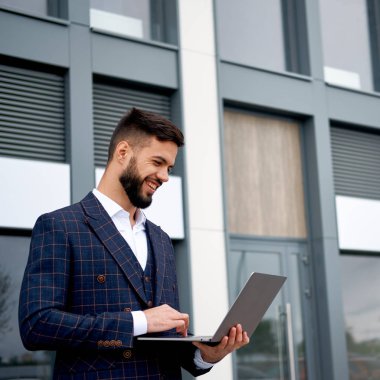 Dizüstü bilgisayar üzerinde çalışan iş adam. İş takım elbiseli adam açık havada üzerinde