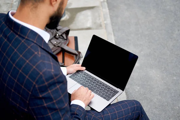 Homem de negócios a trabalhar no computador portátil. Homem em terno de negócios ao ar livre — Fotografia de Stock