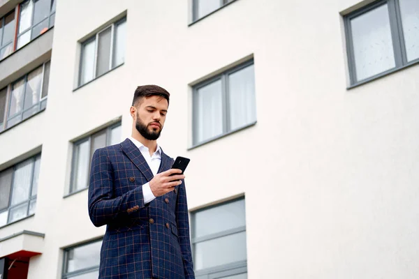 Businessman urban professional business man using mobile phone at office building in city. Professional wearing suit jacket