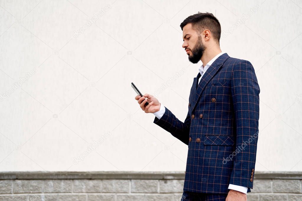 Businessman urban professional business man using mobile phone at office building in city. Professional wearing suit jacket.