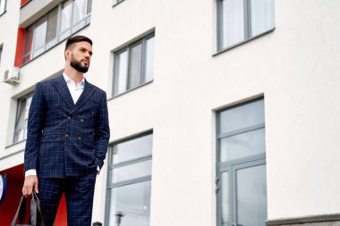 Çekici işadamı seyahat çantası elinde sokakta yürürken