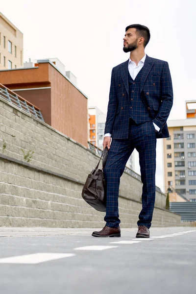 Attraente uomo d'affari che cammina lungo la strada tenendo borsa da viaggio — Foto Stock