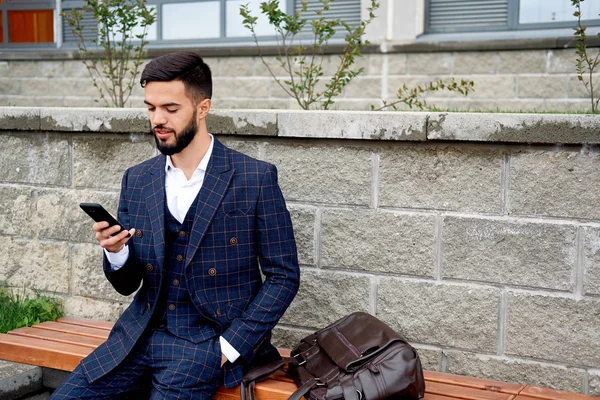 Sakallı işadamı telefon ve güler tarafından konuşuyor. Akıllı telefon kullanan genç çekici iş adam. Müşteriler ile cep telefonuyla konuşan işadamı