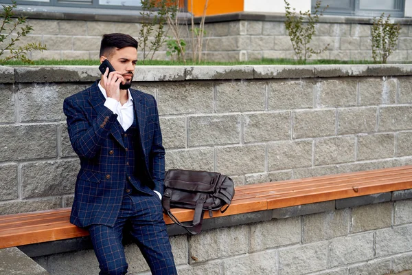 Uomo d'affari barbuto parla per telefono e ride. Giovane uomo d'affari attraente utilizzando smartphone. Uomo d'affari che parla al cellulare con i clienti — Foto Stock