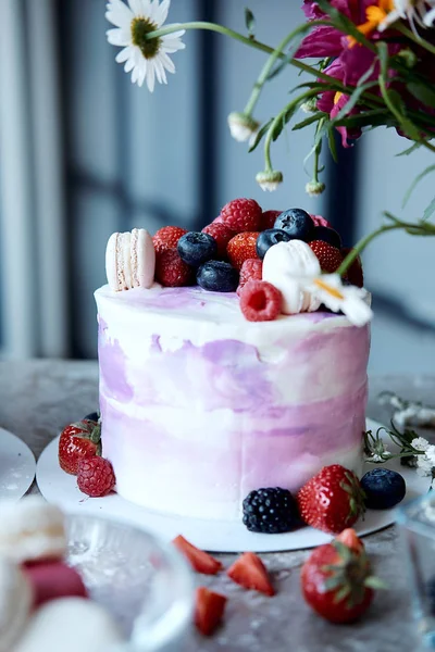 Holiday cake. Sweet desserts with berries and macarons. Cake from the fruit. Delicious sponge cake