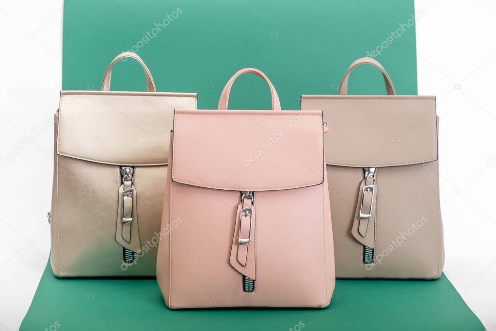 Fashionable women's backpacks on a green background.