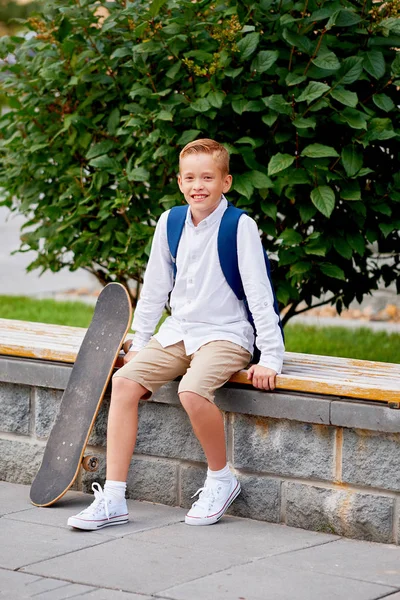 Sırt çantası ve açık havada kaykay ile mutlu gülümseyen okullu çocuk. Çocukluk, eğlence, okul ve insanlar kavramı — Stok fotoğraf