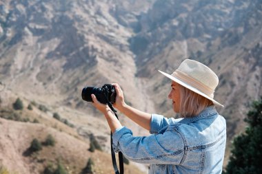 Fotoğrafçı turist ile fotoğraf makinesi dağ dururken ateş eder