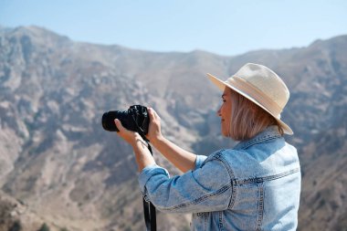 Fotoğrafçı turist ile fotoğraf makinesi dağ dururken ateş eder.