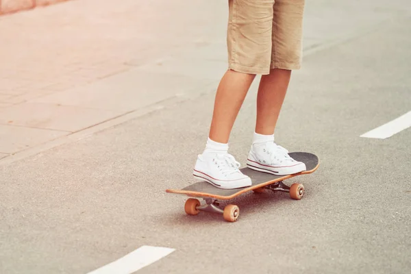 Junge fährt Skateboard in der Stadtstraße. urbaner Lebensstil im Sommer — Stockfoto