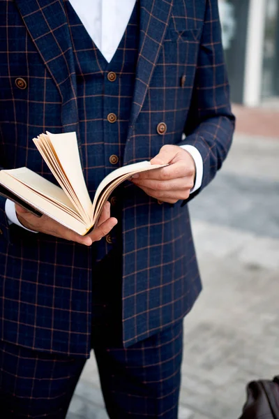 Närbild, ung affärsman med en anteckningsbok i hand, staden bakgrund med byggnader — Stockfoto