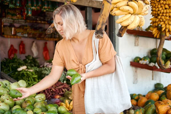 Kadın egzotik kırsal pazardan taze avokado satın aldı — Stok fotoğraf