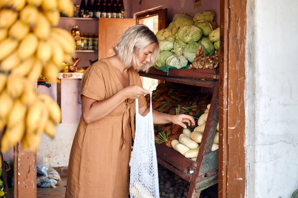 Žena koupit čerstvé ovoce na exotickém místním trhu — Stock fotografie