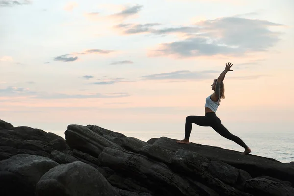 Woman Practicing Yoga in the Nature. Meditating Outdoors. Landscape background