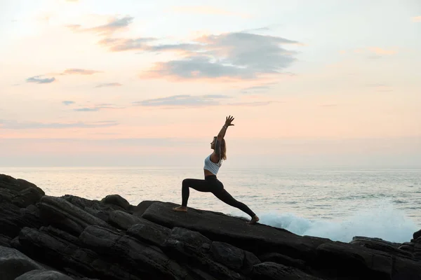 Woman Practicing Yoga in the Nature. Meditating Outdoors. Landscape background